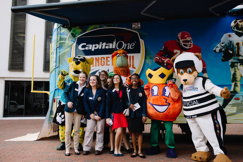 Mascots and students in front of the Orange Bowl display truck
