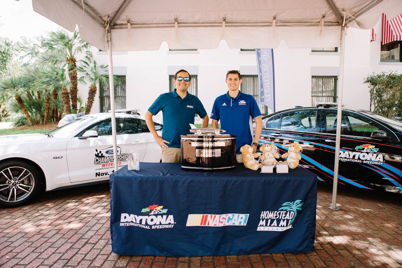 Daytona International Speedway, NASCAR, and Homestead-Miami Speedway display with race cars at a past Sports Day